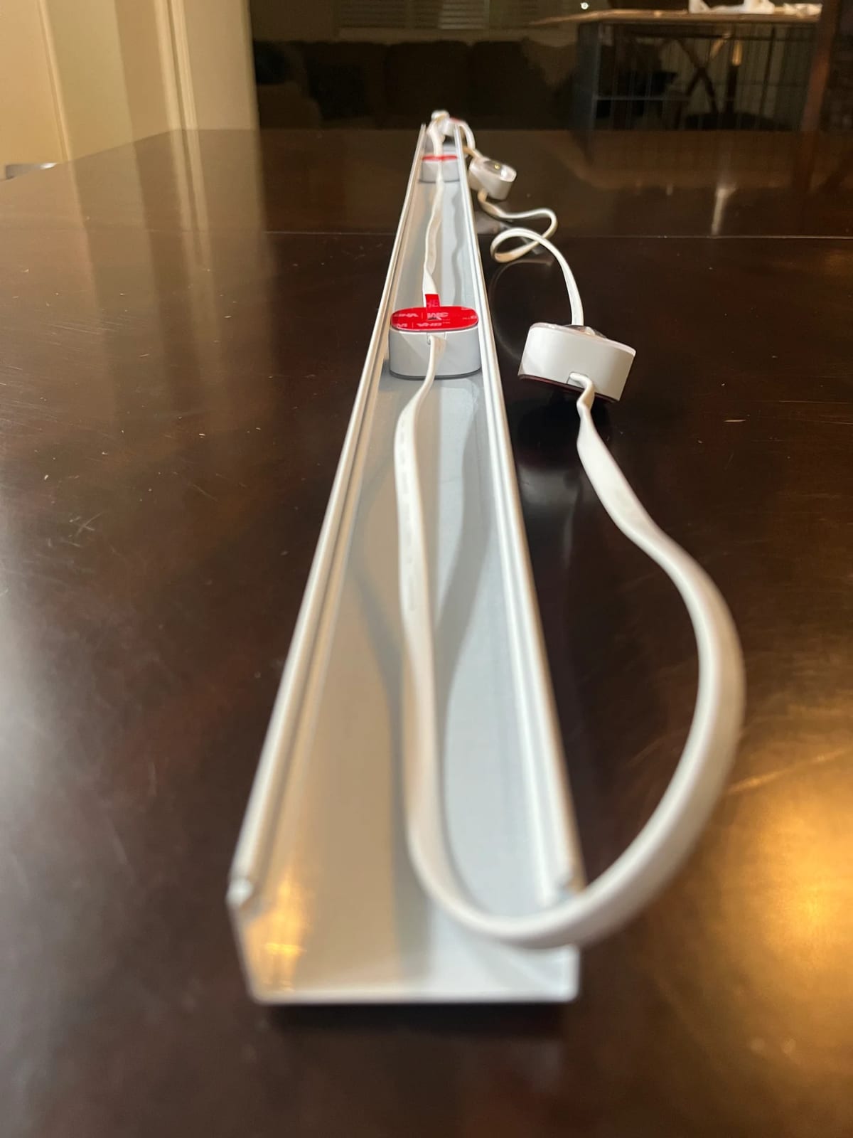 Side profile of the aluminum channel showing the deep U-shape, the bulb seated inside, and the 3M VHB adhesive backing visible.