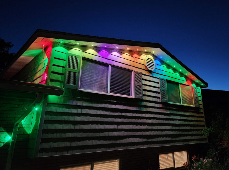 Colorado home with vibrant multicolor permanent LED lights showing red, purple, green, and orange scene on gables and roofline