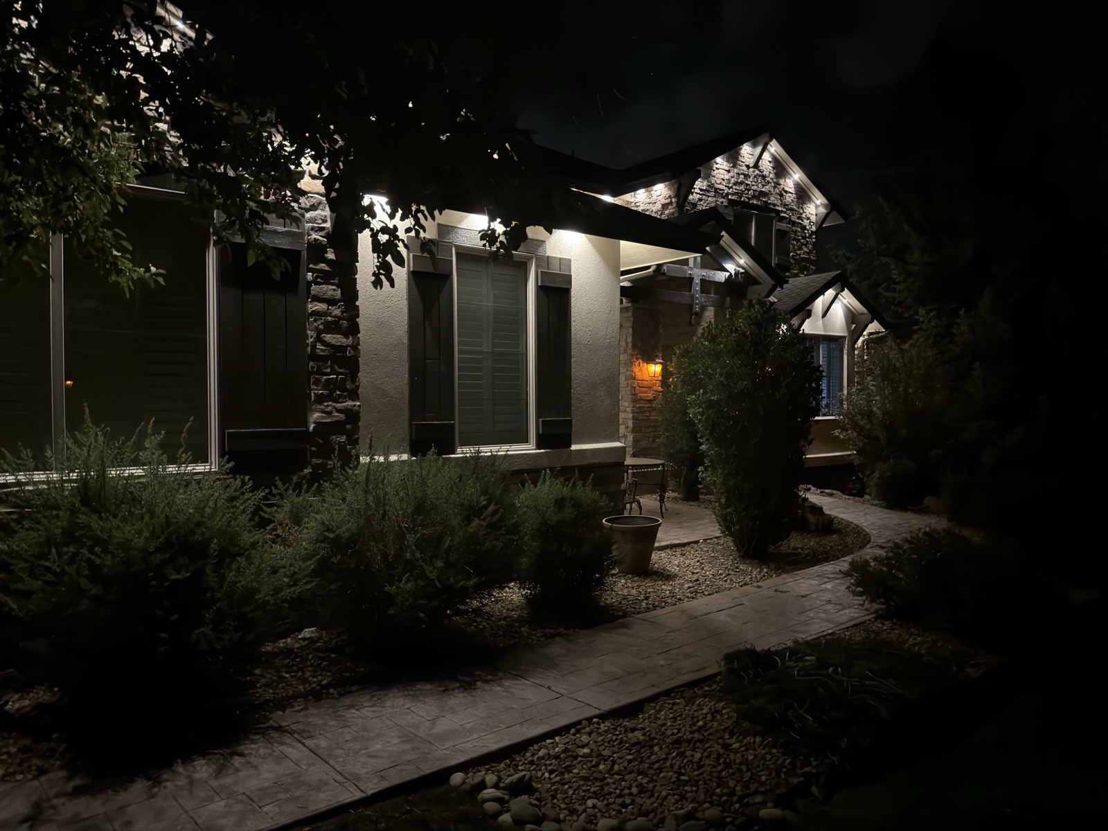 Parker CO stone craftsman home at night with warm white permanent LED lights glowing along the full perimeter roofline, installed in concealed SnapTrack aluminum channel.