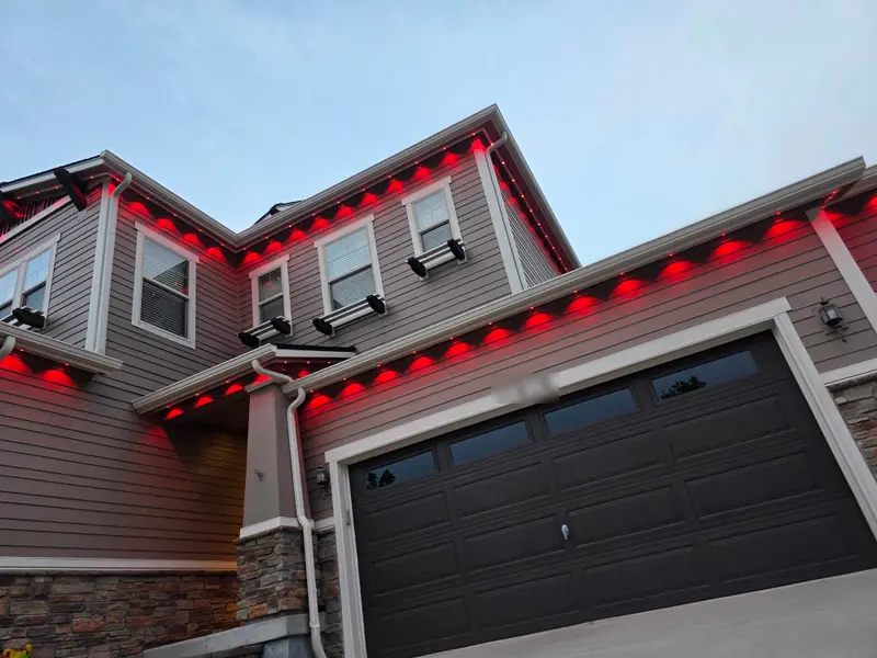 Angled view of a two-story Denver Metro home at dusk with Govee Pro permanent lights in SnapTrack glowing solid red along the roofline