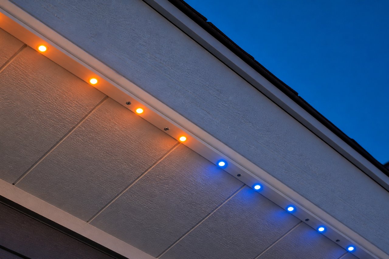 Close-up of permanent outdoor LED lights installed inside powder-coated aluminum SnapTrack channel mounted to a soffit